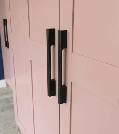 Matte Black Aluminum Cabinet Handle with Ribbed Texture on Pink Wardrobe Door