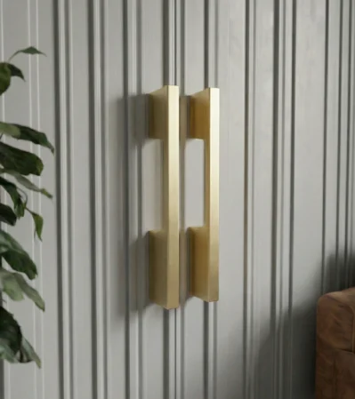 Pair of brushed gold square bar cabinet handles mounted on ribbed grey cabinet panels